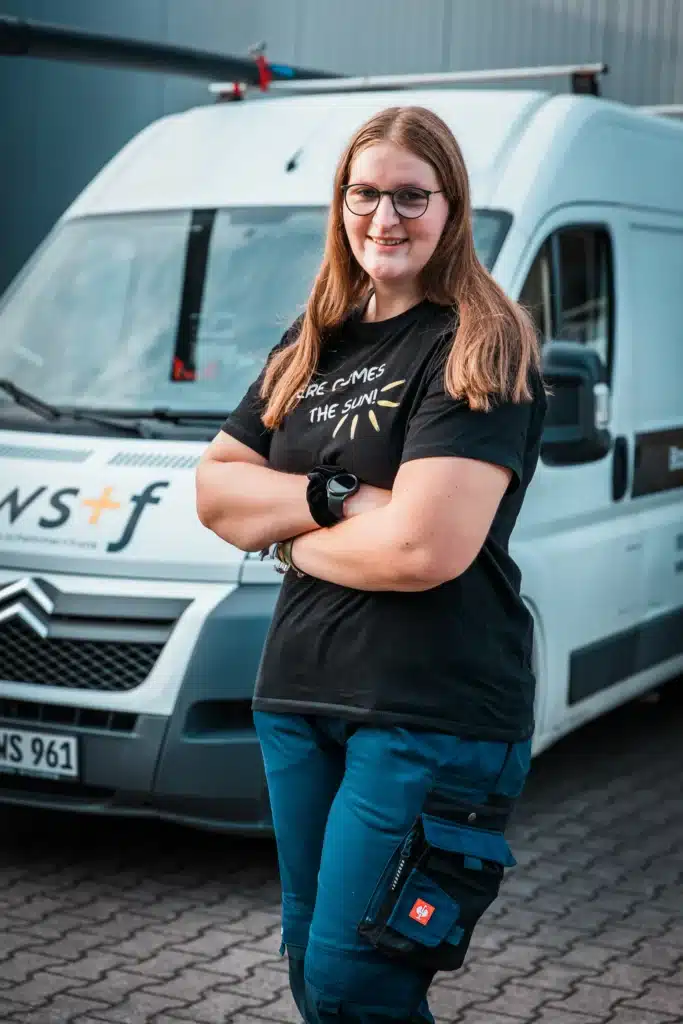 Mitarbeiterin steht vor einem ws+f-Servicefahrzeug.